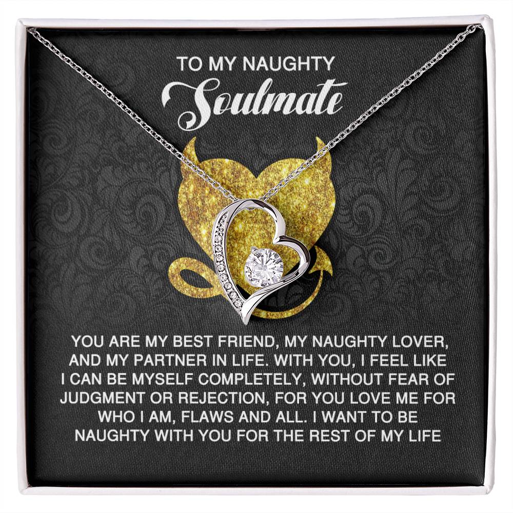 The Soulmate-Naughty With You - Forever Love Necklace features a heart-shaped design with a central gem in a gold finish. It's beautifully presented in a black box labeled "To My Naughty Soulmate," adorned with a heartfelt message in white text over a gold heart graphic.