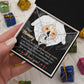 A person holds a gift box containing the "To Mom To Be, An Incredible Job - Forever Love Necklace" with a heartfelt message addressed to "Mommy." The beautiful white gold necklace pendant is nestled inside, surrounded by small wrapped presents, making it the perfect personalized gift.