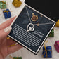 A hand holds the Soulmate-Eternal Happiness - Forever Love Necklace, a heart-shaped pendant with a CZ crystal in white gold, displayed in a box with a sentimental message. Small wrapped gifts are in the background.