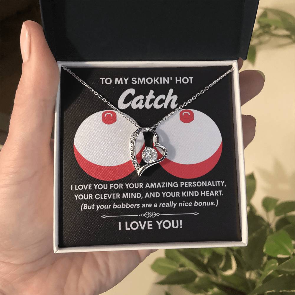 A person opens a box to reveal the Soulmate-Nice Bonus - Forever Love Necklace, featuring a heart-shaped pendant in white gold finish. A humorous love message inside the lid enhances the charm of this keepsake, which is highlighted by a dazzling 6.5mm CZ crystal.