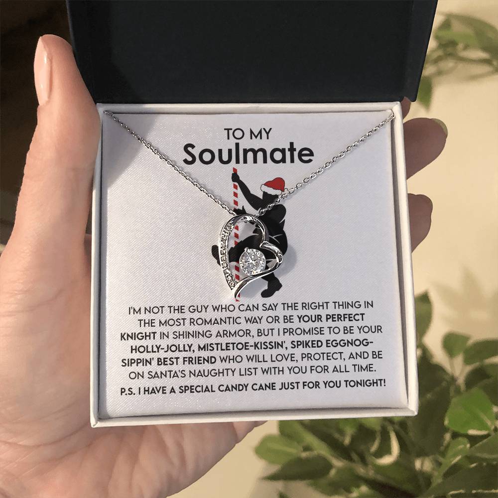 A hand holds the Soulmate-For All Time - Forever Love Necklace, a captivating piece featuring intertwined hearts with a gold finish and CZ crystal, beautifully presented in a gift box. Inside the lid lies a heartfelt message for a soulmate, perfectly encapsulating the spirit of holidays and love.