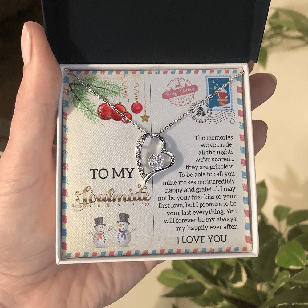 A person holds a necklace gift box featuring the Soulmate-Last Everything - Forever Love Necklace, showcasing a heart-shaped pendant in a shimmering gold finish, accented with a sparkling cubic zirconia stone, and accompanied by a heartfelt message inside.