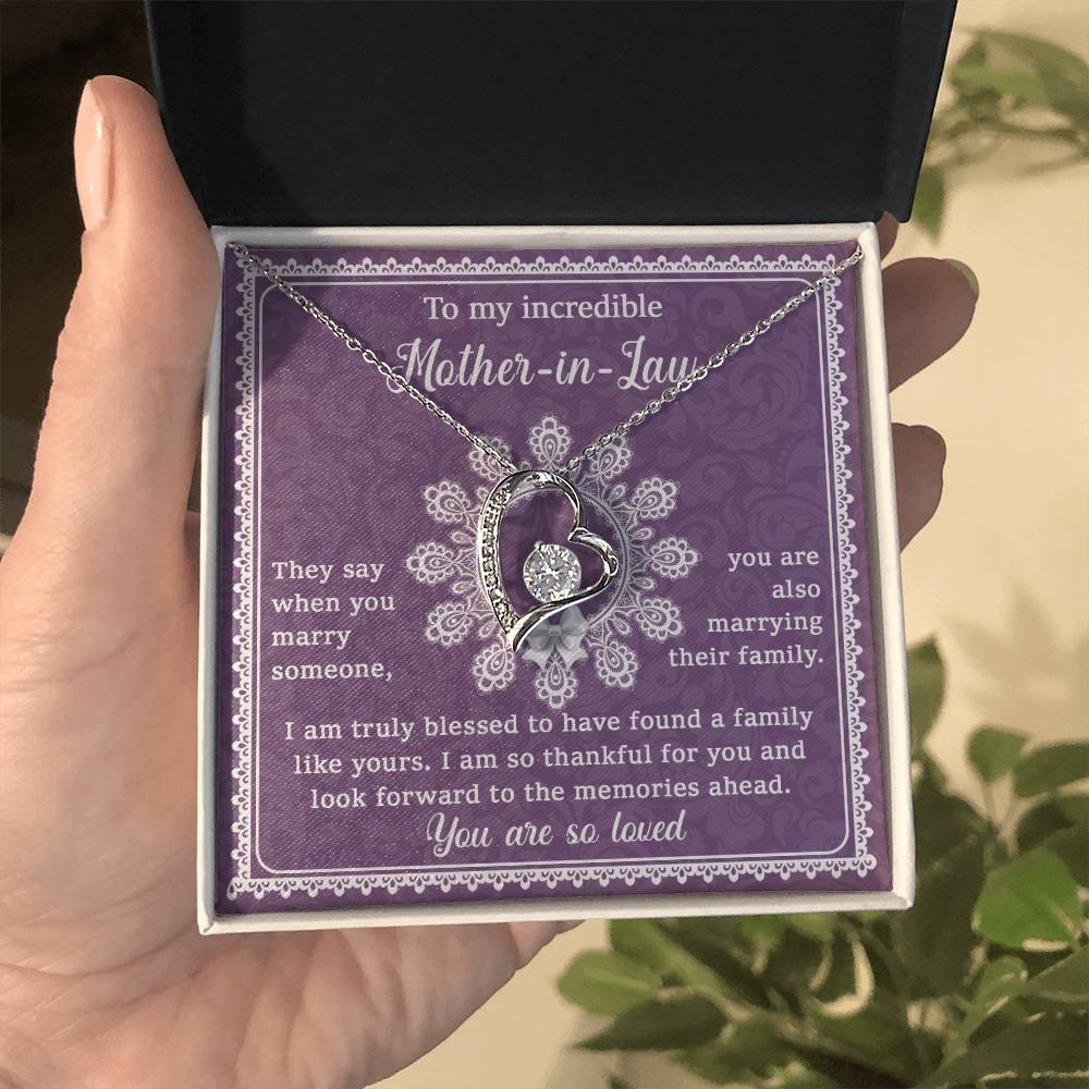 A gift box with a personalized jewelry piece, the "To Mother-In-Law, Family Like Yours - Forever Love Necklace," a pendant shaped like a heart and an engraved message on a purple background, dedicated to a mother-in-law.