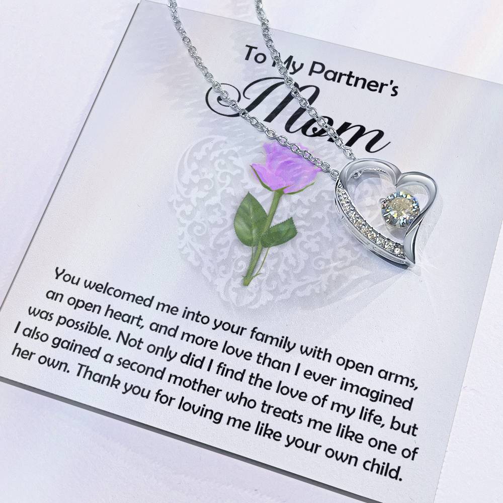 The Partner's Mom-A Second Mother - Forever Love Necklace features a heart-shaped design with a cubic zirconia gem and white gold finish, presented on a "To My Partner's Mom" card with a purple rose and an appreciative message.