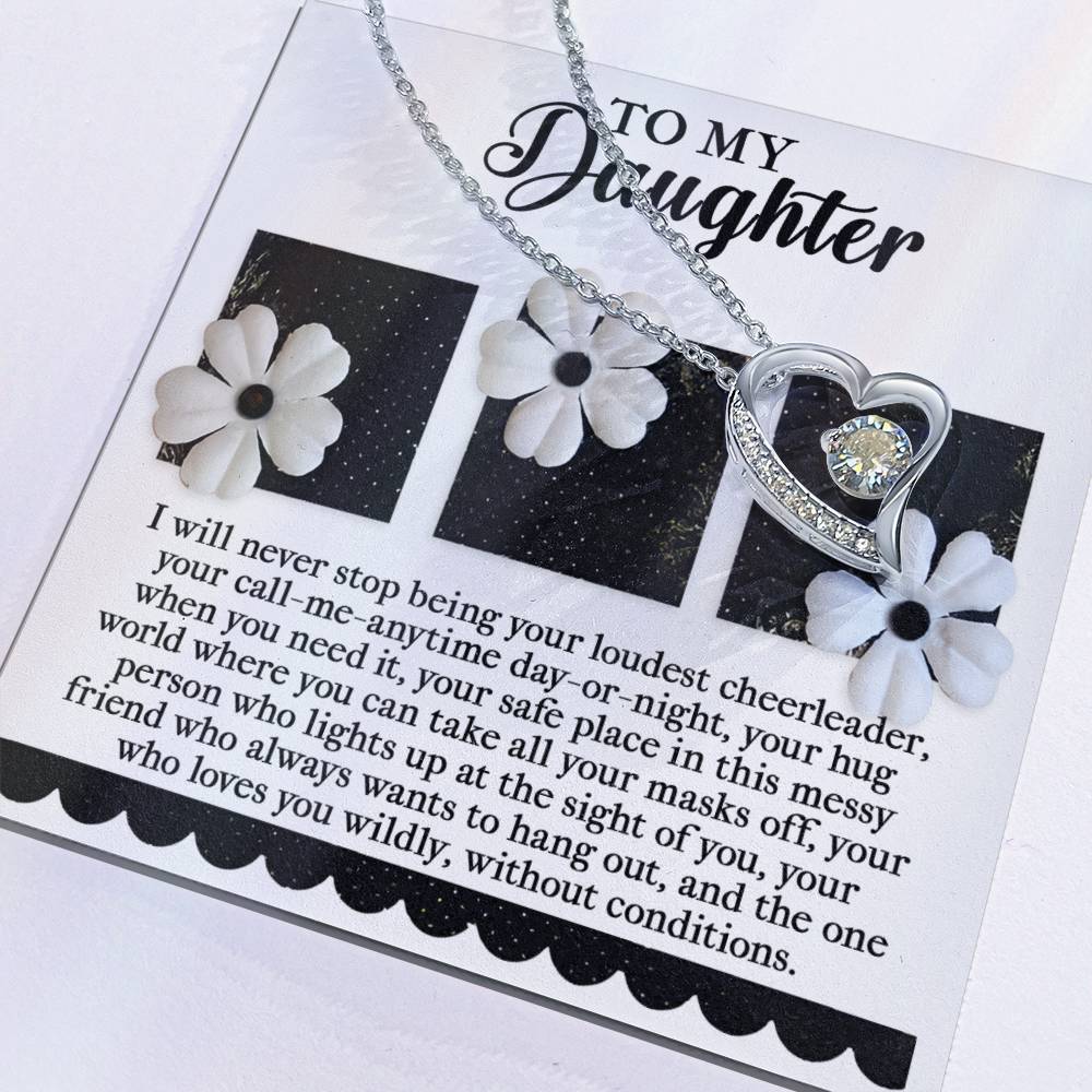 The "Daughter-Loudest Cheerleader - Forever Love Necklace" showcases a silver heart-shaped pendant embellished with CZ crystals, beautifully presented on a card with heartfelt messages and adorned with delicate white flower embellishments.