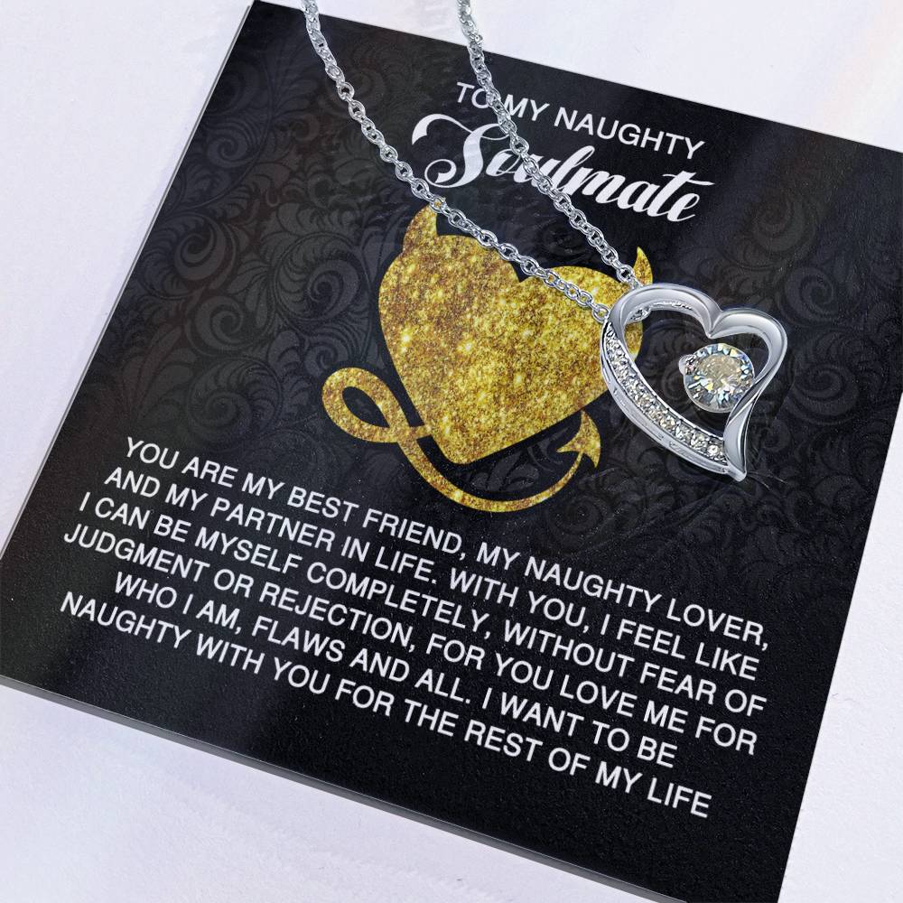 The Soulmate-Naughty With You - Forever Love Necklace, showcasing a heart-shaped pendant with a central cubic zirconia stone, rests on a card expressing love and companionship. Its gold finish adds elegance to this timeless symbol of affection.