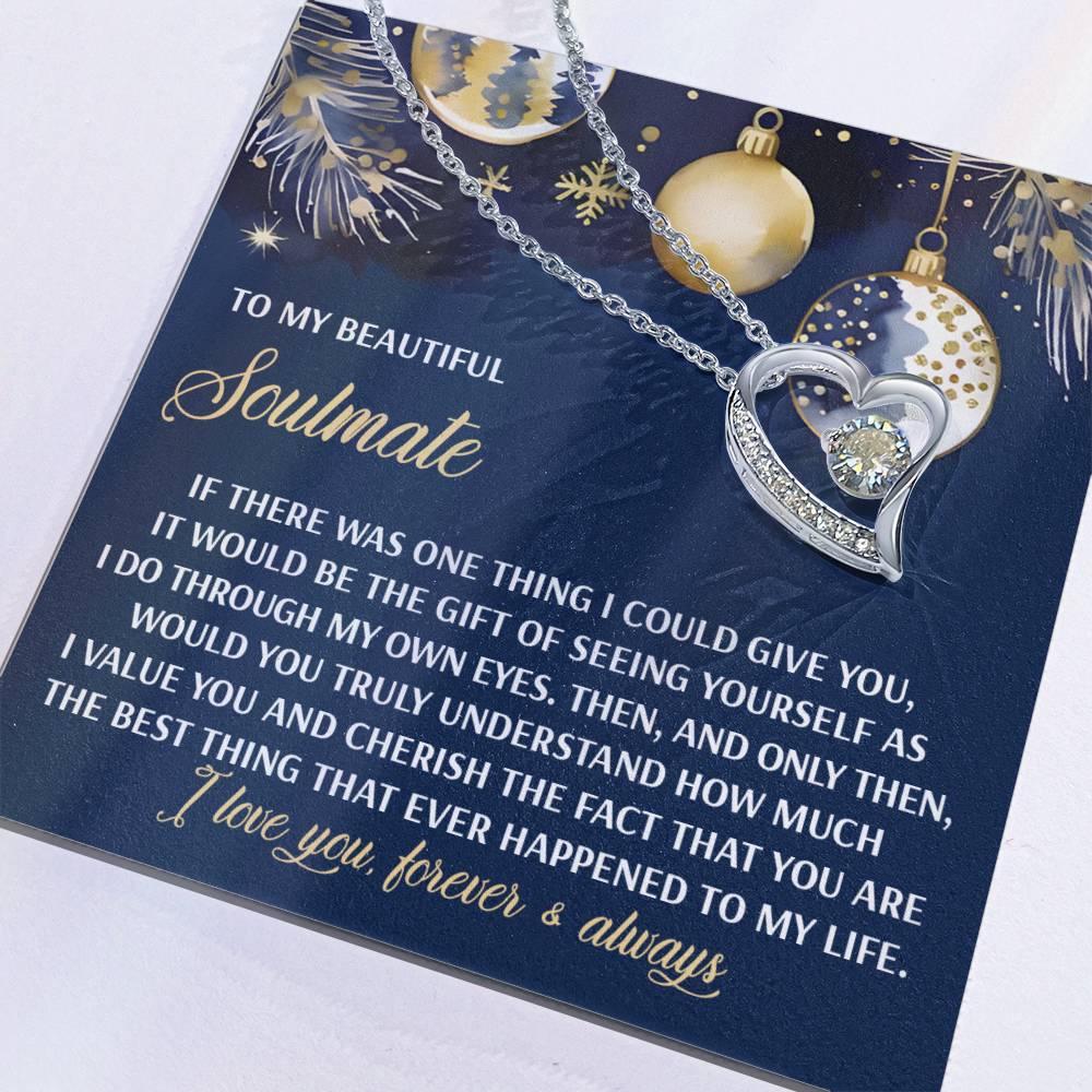 The Soulmate-One Thing - Forever Love Necklace, featuring a silver heart and a dazzling cubic zirconia stone, is displayed on a card embellished with festive gold and blue designs. This meaningful gift is perfect for your soulmate.