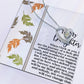 The Daughter-Biggest Fan - Forever Love Necklace, showcasing a silver heart-shaped pendant with a cubic zirconia gemstone, is displayed on a card embellished with autumn leaves and an inspiring message about transformation and steadfast support.