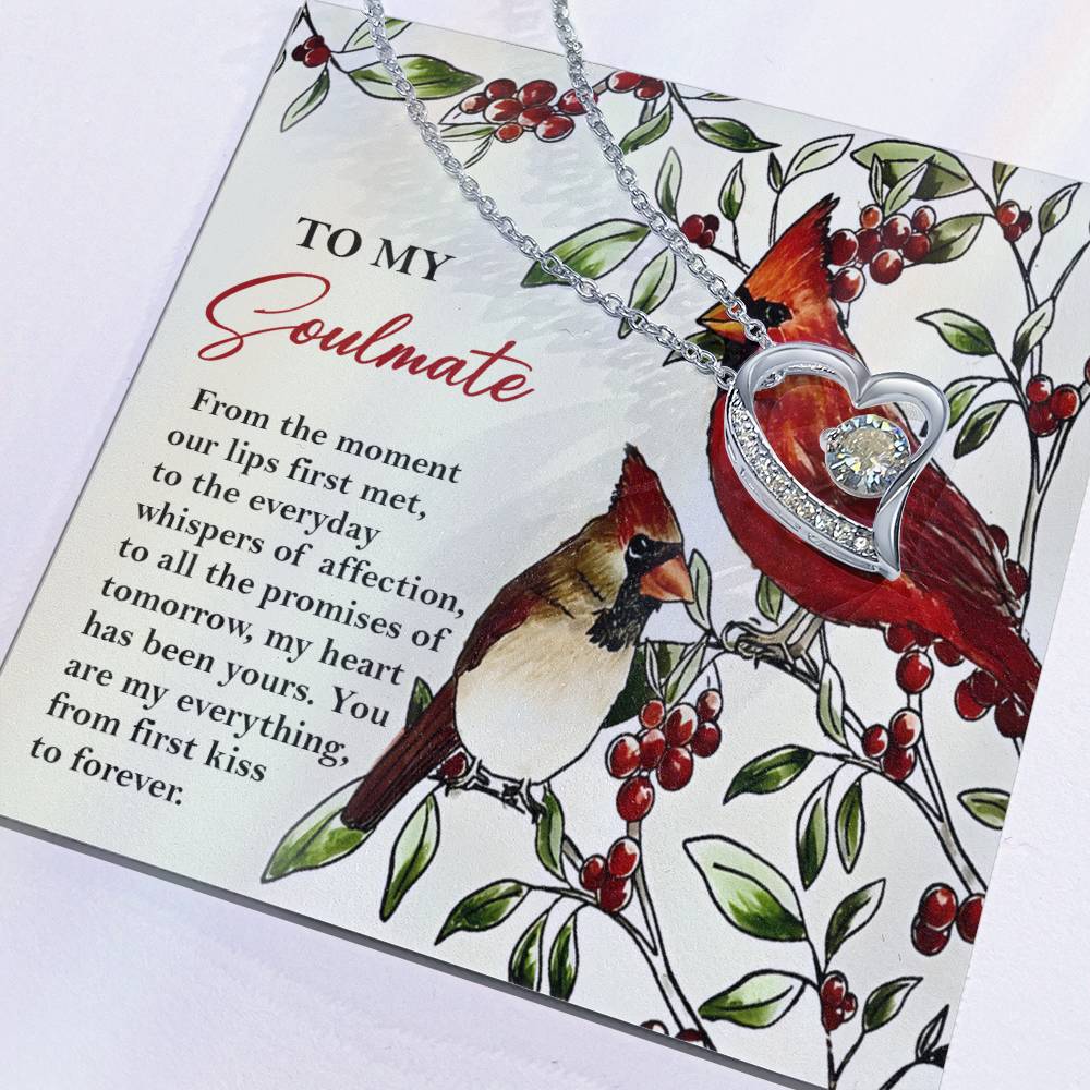 Greeting card featuring the Soulmate-First Kiss - Forever Love Necklace, adorned with a heart pendant incorporating a CZ crystal and a gold finish, set in a design with two cardinals and branches adorned with red berries, alongside the loving message titled "To My Soulmate." A perfect symbol of enduring love.