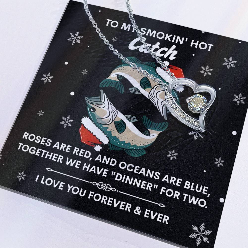 The Soulmate-Oceans Are Blue - Forever Love Necklace showcases a heart-shaped, gold-finished pendant. It elegantly sits on a card with fish illustrations and a love poem. The pendant features a sparkling cubic zirconia stone, symbolizing an everlasting bond.