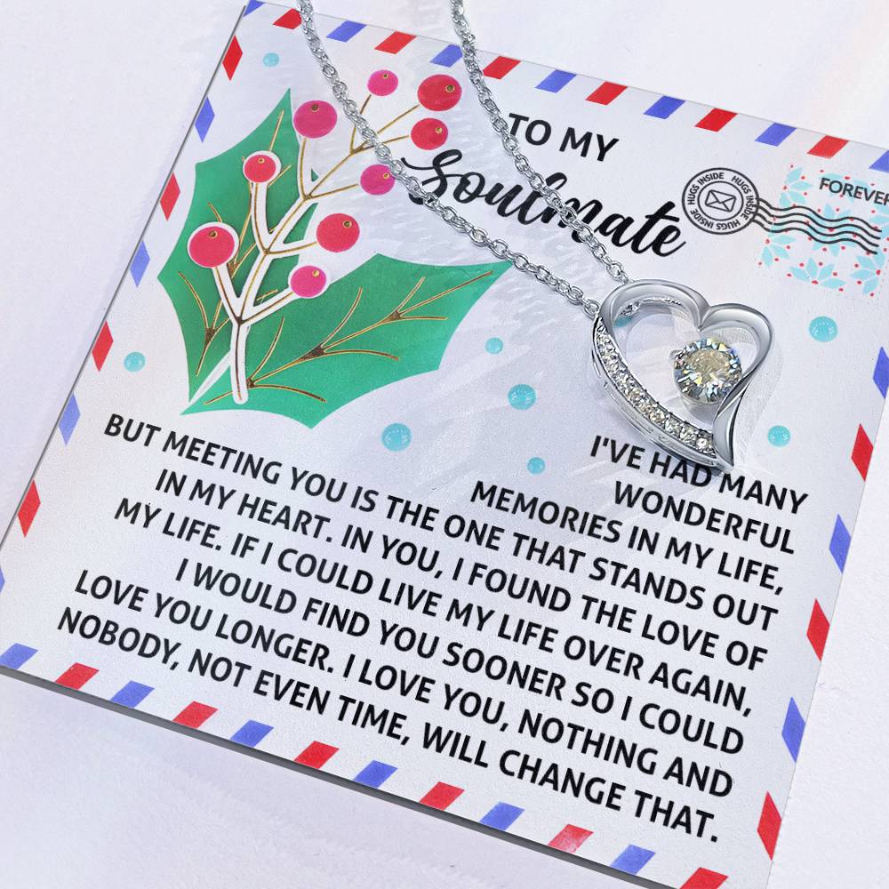 The Soulmate-Love You Longer - Forever Love Necklace showcases a heart-shaped pendant with a gold finish, gracefully presented on a decorative card embellished with a holly design and CZ crystal accents. It includes a touching message about love and soulmates, making it an ideal gift for someone special.