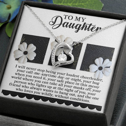 The Daughter-Loudest Cheerleader - Forever Love Necklace showcases a heart-shaped pendant embellished with a dazzling CZ crystal, beautifully finished in luxurious gold. It is elegantly presented on a card with floral designs, complete with a heartfelt message to your daughter.