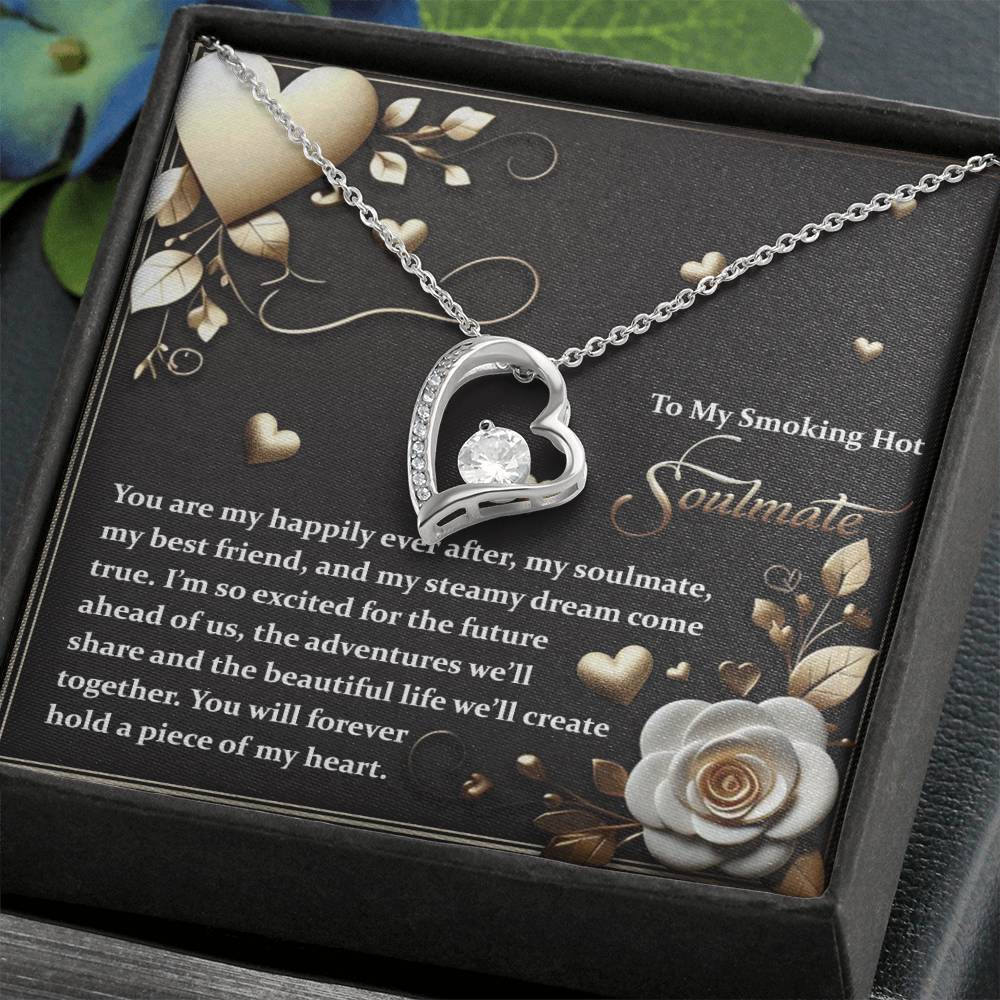 The Soulmate-The Future - Forever Love Necklace features a heart-shaped pendant with a sparkling diamond and comes in a box that reads "To My Smoking Hot Soulmate," along with a romantic message. It has floral designs, small hearts, and a gold finish for capturing unforgettable moments.