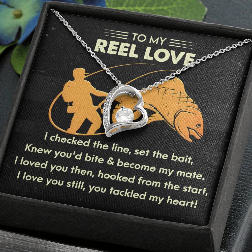 The Soulmate-Tackled My Heart - Forever Love Necklace includes a silver heart-shaped pendant with a central CZ crystal. Packaged in a gift box with fishing-themed text and illustration inside the lid, it's also available in an elegant gold finish.