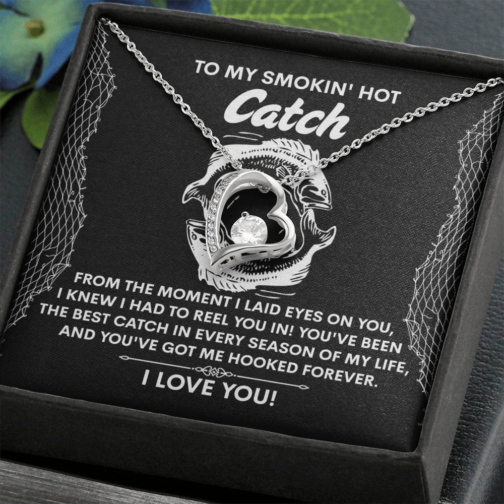 The Soulmate-Got Me Hooked Necklace, silver heart-shaped with a CZ crystal, is elegantly presented on a card with a romantic fishing-themed message, all within a luxurious white gold-finished gift box.