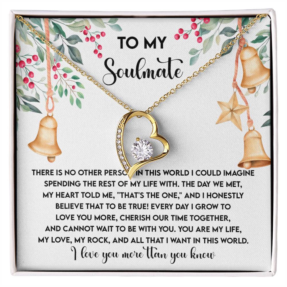 The Soulmate-Be With You - Forever Love Necklace, adorned with a heart-shaped CZ crystal pendant and a gold finish, is elegantly presented on a card featuring a message about love and soulmates, amidst festive decorations.