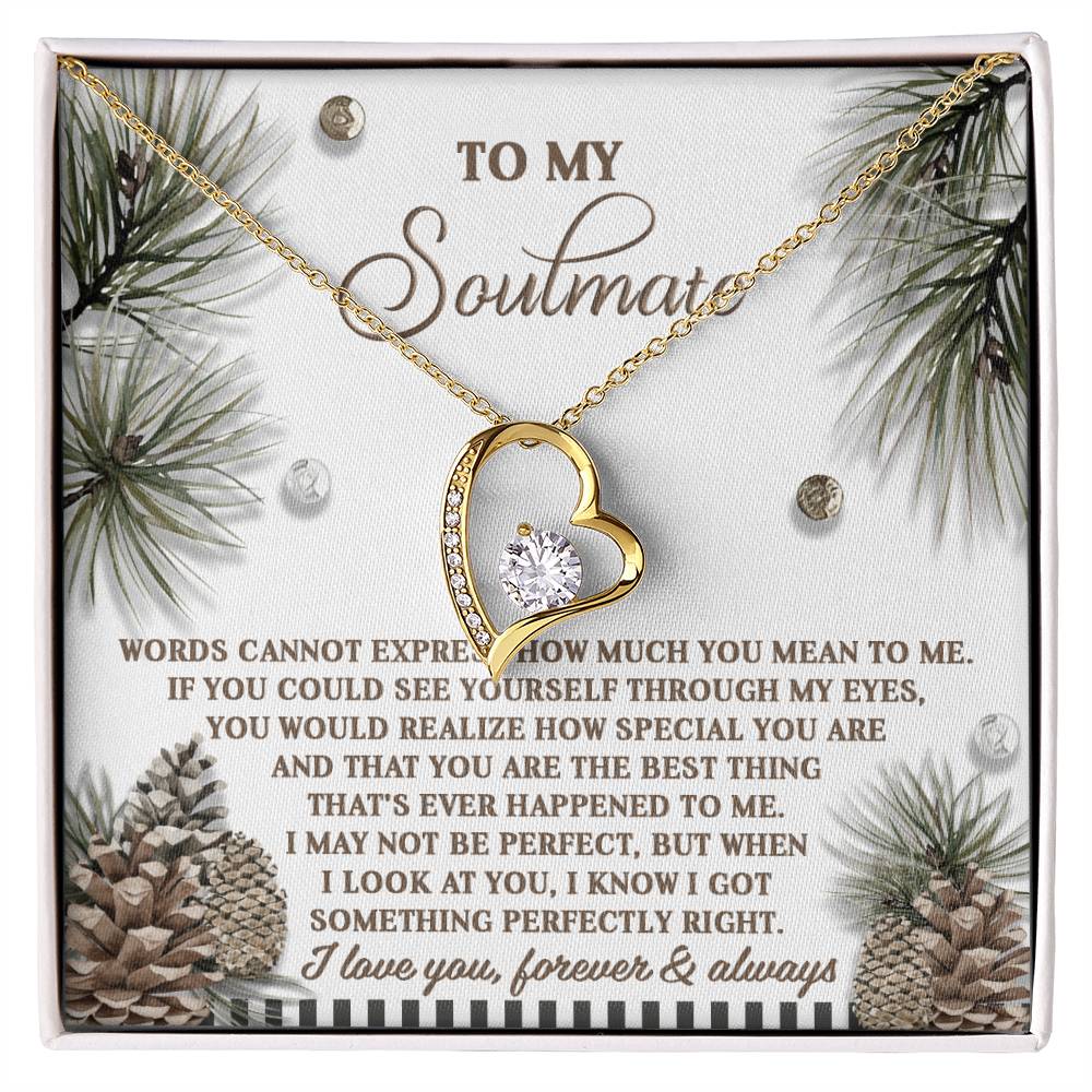 The Soulmate-Perfectly Right - Forever Love Necklace features a gold heart-shaped pendant and sparkling CZ crystal, elegantly displayed on a card decorated with pinecone and pine needle motifs. Its white gold finish beautifully enhances the romantic message included.