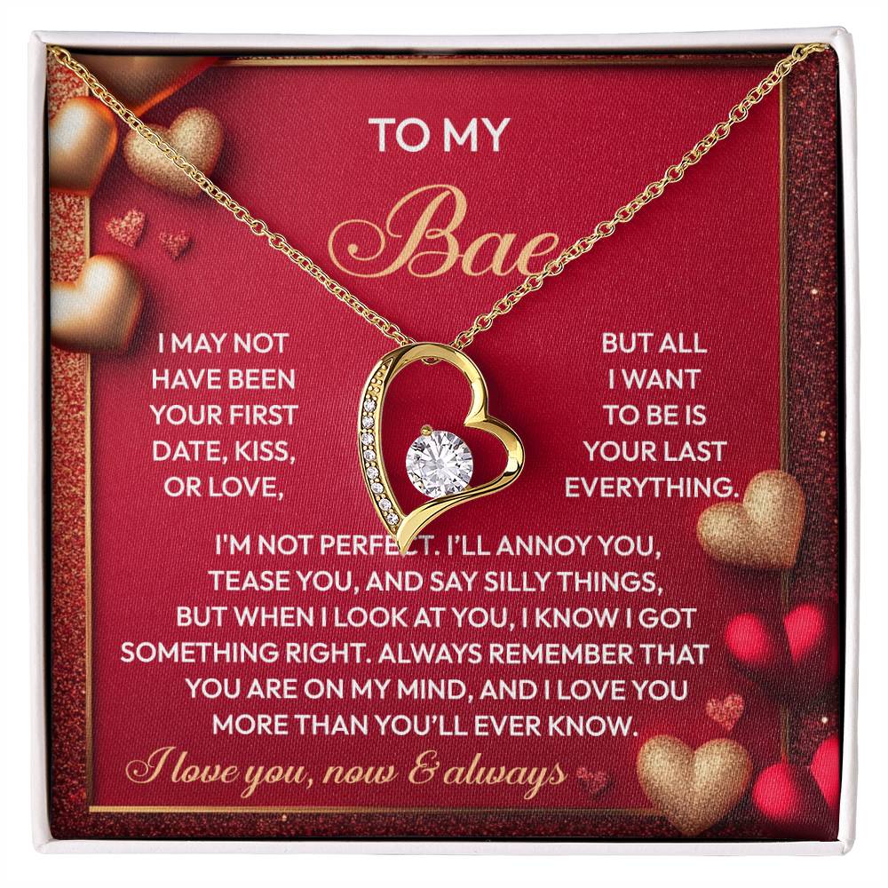 The Soulmate-On My Mind: Forever Love Necklace showcases a gold heart with a central CZ crystal. It's presented on a red card titled "To My Bae," bearing a heartfelt love message. Its white gold finish lends elegance, making it a perfect romantic gift.