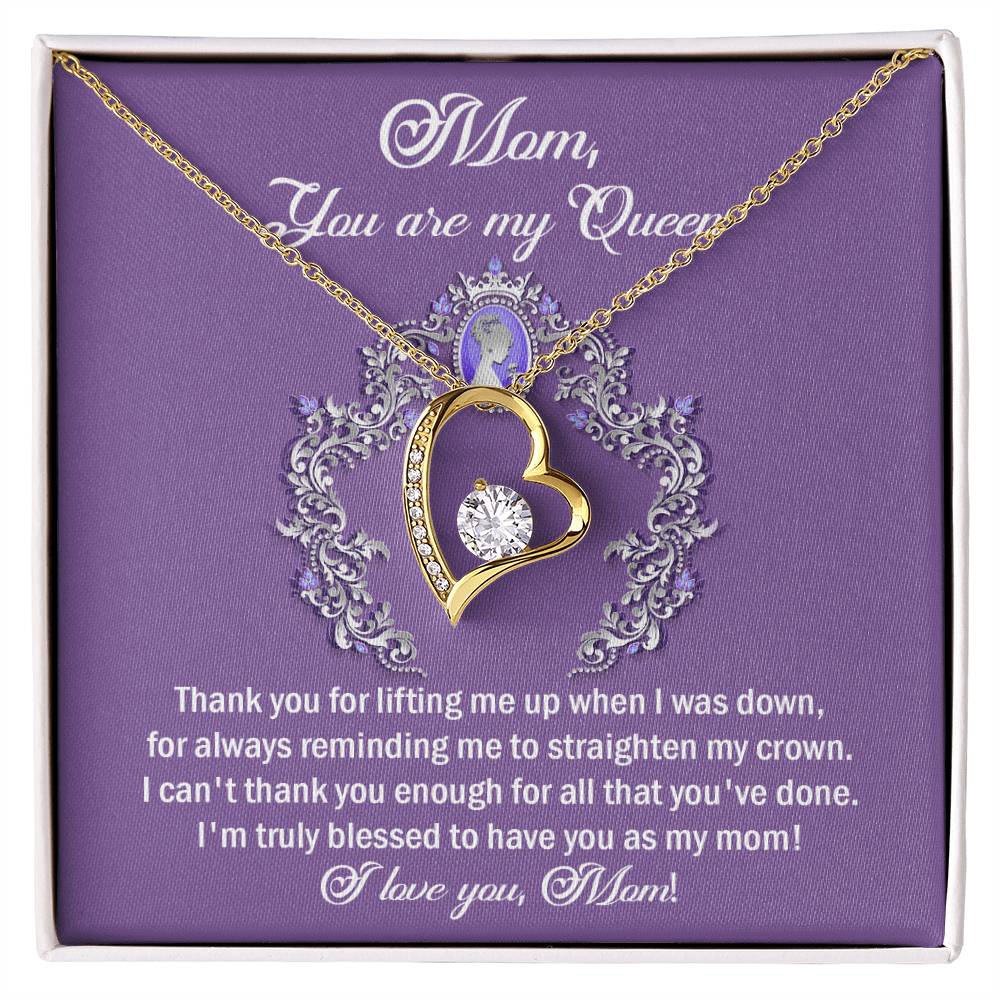 A gold, heart-shaped pendant necklace adorned with a central cubic zirconia stone is placed over a purple card bearing the message: "Mom, You are my Queen" and a heartfelt thank you note. The "To Mom, Belongs To Me - Forever Love Necklace" is the perfect personalized gift for expressing your endless appreciation and love.