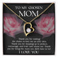 The 'To Bonus Mom, My Chosen Mom - Forever Love Necklace' features a heart-shaped pendant adorned with a gemstone and is displayed on a cushion surrounded by roses. It includes a heartfelt message expressing gratitude and love to your chosen mom. Available in either white gold or yellow gold finish, this piece makes an ideal Mother's Day gift.