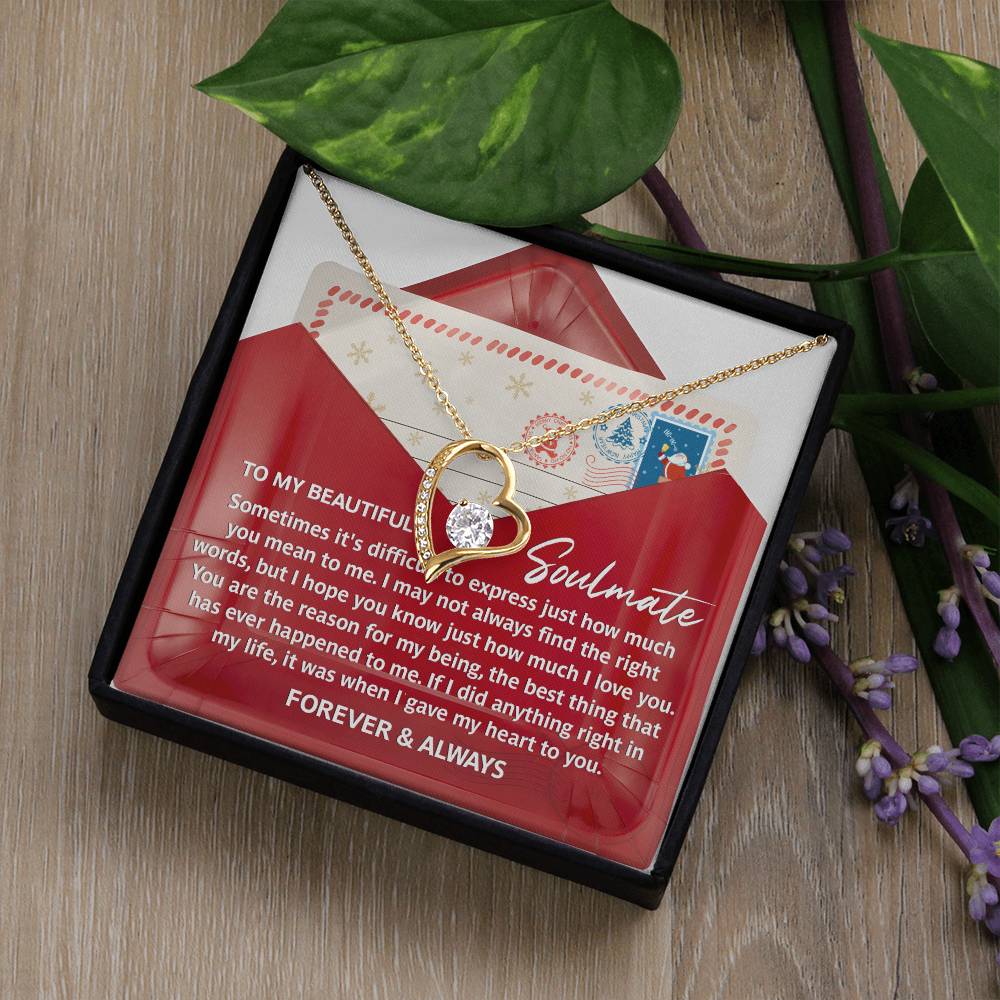 The Soulmate-Right Words - Forever Love Necklace, featuring a gold finish and circular pendant, is beautifully presented in a gift box. The box contains a heartfelt message along with decorative elements like a small envelope and greenery, making it an ideal keepsake.