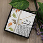 The Daughter-Biggest Fan - Forever Love Necklace features a heart-shaped pendant that sparkles with a gold finish and cubic zirconia crystal, elegantly presented in a charming gift box. Inside, the box includes a heartfelt message for a daughter, beautifully accented with decorative leaves and lush green foliage.