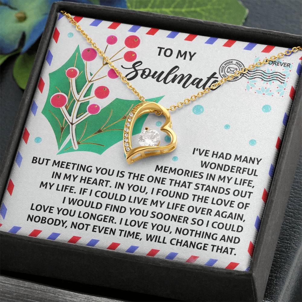 The Soulmate-Love You Longer - Forever Love Necklace features a captivating heart-shaped pendant in gold, embellished with a CZ crystal, and is elegantly suspended on a chain. This exquisite piece comes on a stylish card adorned with decorative text and a holly illustration, perfectly finished with a gleaming white gold coating.