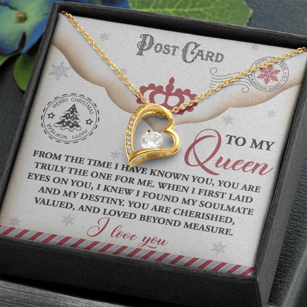 The Soulmate-The One - Forever Love Necklace showcases a gold heart embellished with a delicate cubic zirconia gem, beautifully presented on a card that bears the heartfelt message "To my Queen" and adorned with elegant decorations, all encased in an exquisite gift box.