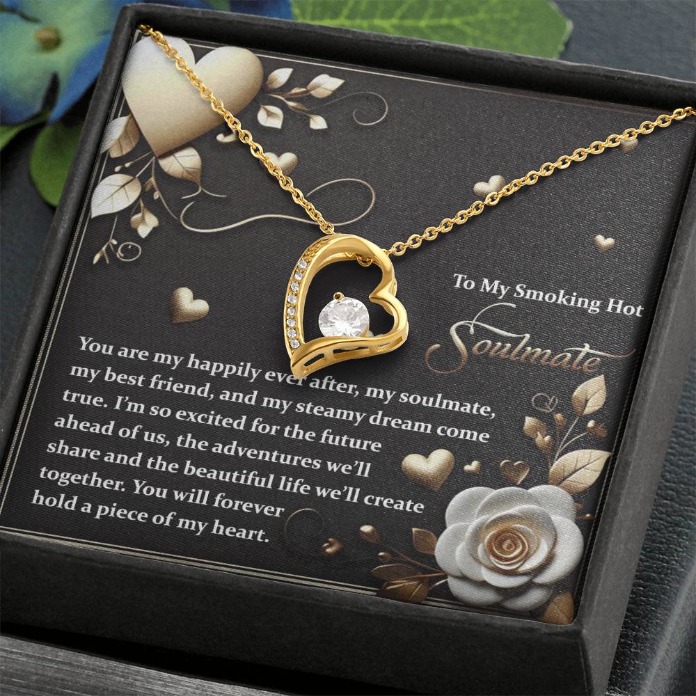 The Soulmate-The Future - Forever Love Necklace, a gold heart-shaped piece with a stunning cubic zirconia center, is elegantly displayed in a box with a romantic message and floral design.