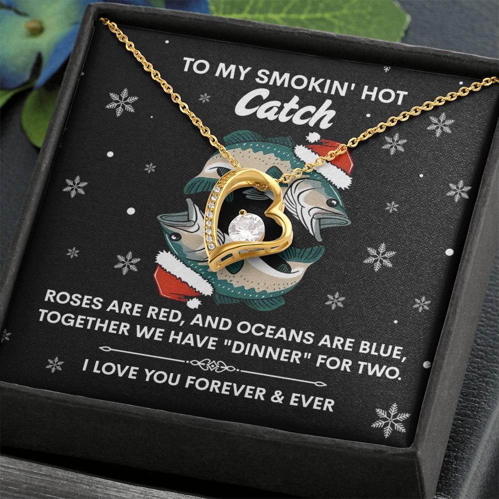 The Soulmate-Oceans Are Blue - Forever Love Necklace, crafted in gold with a cubic zirconia stone, is presented in a black jewelry box. The backdrop includes fish and snowy motifs with the message "To my smokin' hot catch" and a romantic poem.