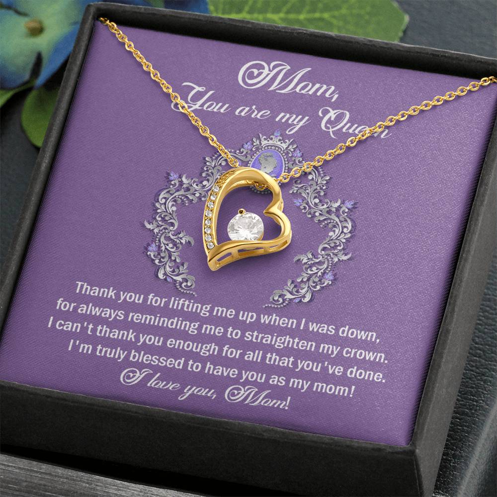 A heart-shaped gold "To Mom, Belongs To Me - Forever Love Necklace" with a gemstone pendant on a purple card that reads, "Mom, you are my queen," accompanied by a heartfelt appreciation message to a mother.