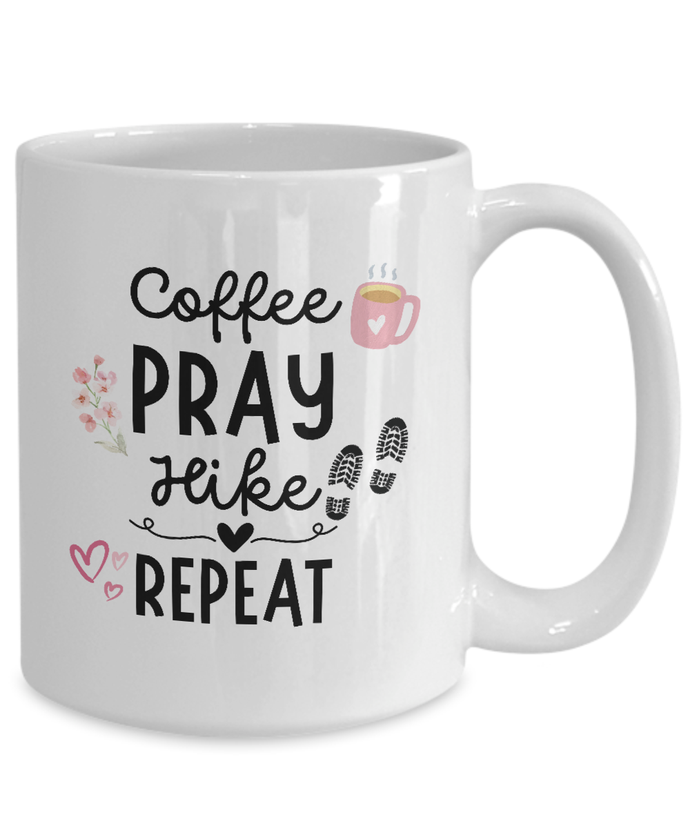 White "Coffee Pray Hike Repeat" mug with delightful graphics of a coffee cup, flowers, hearts, and footprints. Available for a limited time only and printed and shipped from the USA. Ideal gift for hikers!.