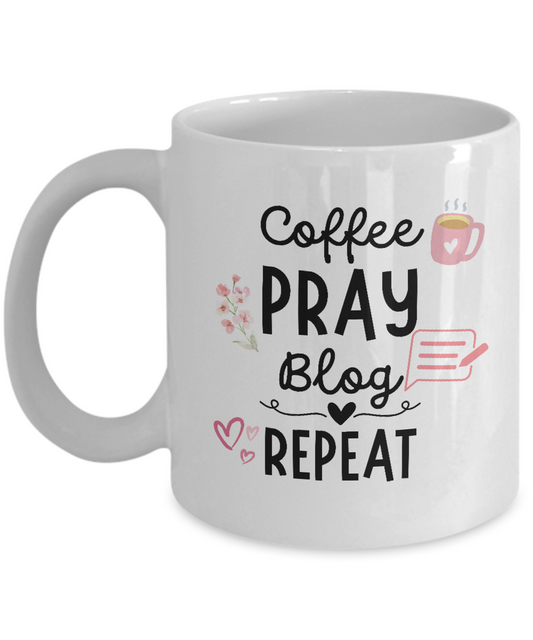 The "Coffee Pray Blog Repeat Coffee Mug" is a white mug featuring the text, "Coffee, Pray, Blog, Repeat" in black and pink letters. It is adorned with small illustrations of a coffee cup, flowers, hearts, and a computer monitor. Printed and shipped from the USA with guaranteed safe checkout, this mug makes an excellent gift and appreciation item for bloggers.