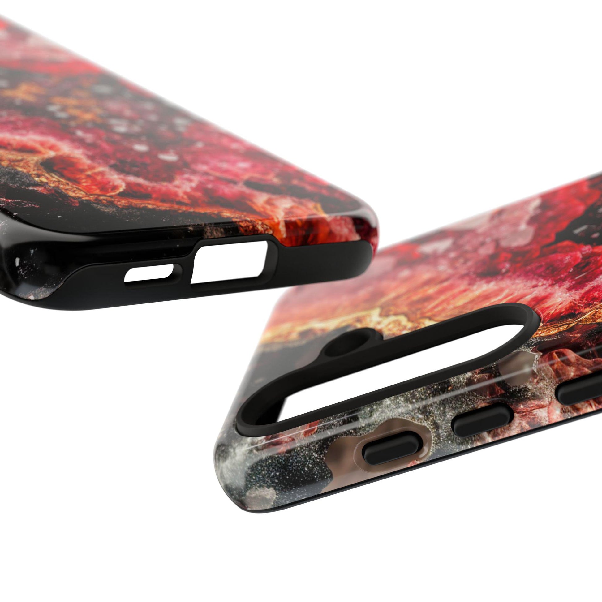 Close-up of two January Birthstone Garnet Crystal Geode Design phone cases displaying a red, black, and white marbled pattern with precise cutouts for buttons and ports.