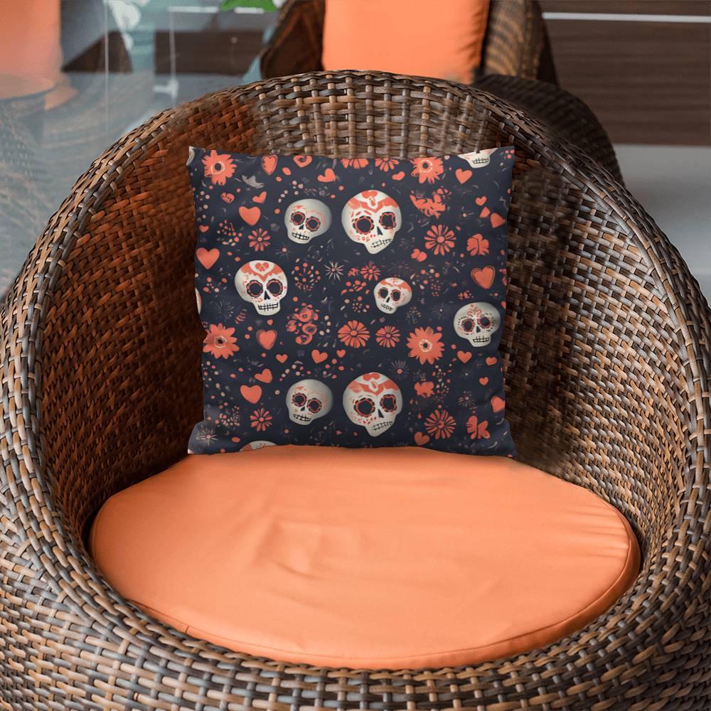 A wicker chair with an orange cushion and the "Day of the Dead Mexican Skull Pillow"—a decorative pillow that showcases sugar skull designs, featuring a skull and floral pattern in red and white on a dark background—is perfect for adding a touch of goth home decor.