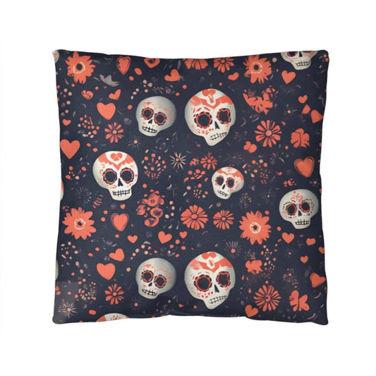 Front view of a square skull pillow is adorned with intricate sugar skull designs, featuring vibrant floral patterns and heart-shaped motifs. The dark background contrasts beautifully with the red, white, and orange decorations.