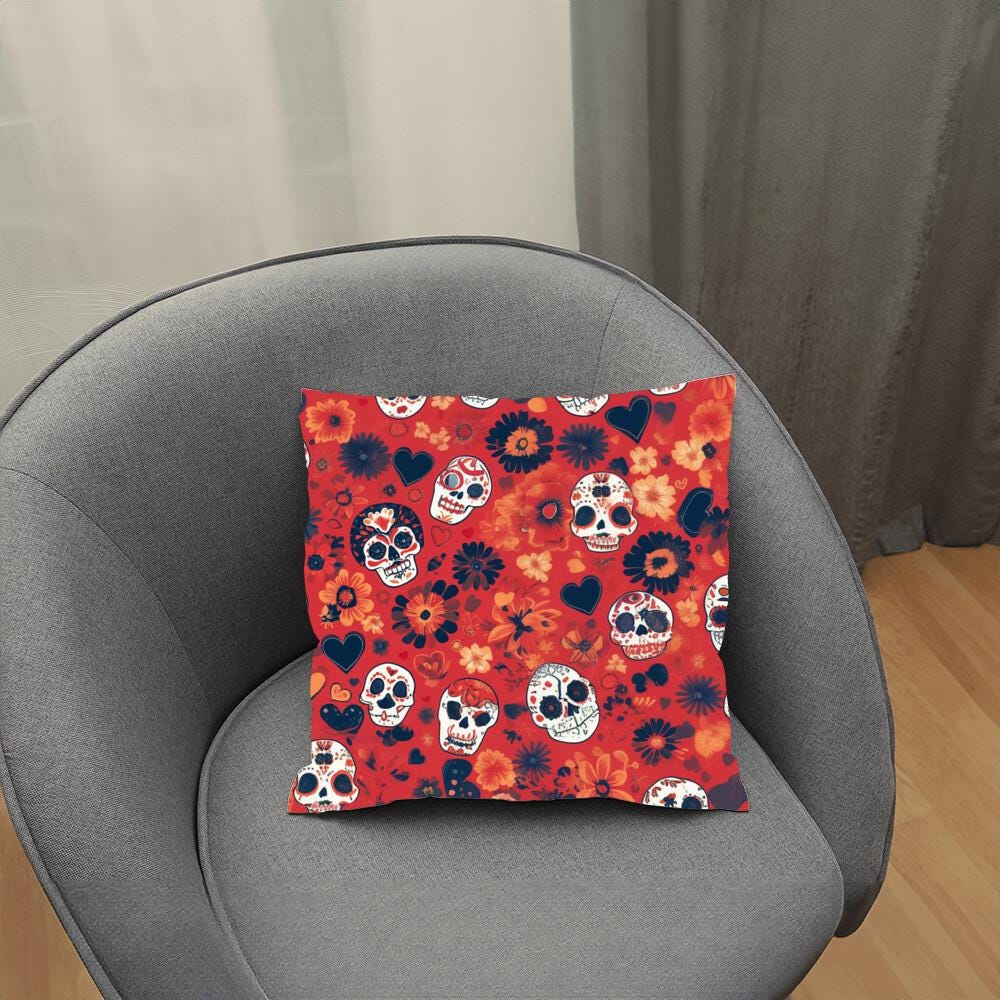 A gray armchair adorned with the Day of the Dead Mexican Skull Pillow, featuring sugar skulls and floral patterns, is perfect for adding a touch of gothic home decor.