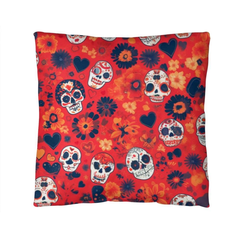 Front view of a sqaure Day of the Dead Mexican Skull Pillow featuring a striking pattern of decorated skulls, flowers, and hearts over a red background.