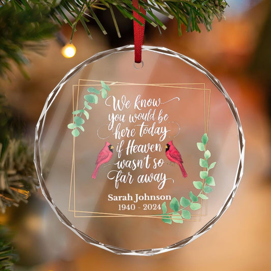 A personalized crystal glass ornament hung on a Christmas tree featuring a touching message: &quot;We know you would be here today if Heaven wasn&#39;t so far away,&quot; accompanied by the name Sarah Johnson and years 1940 - 2024.