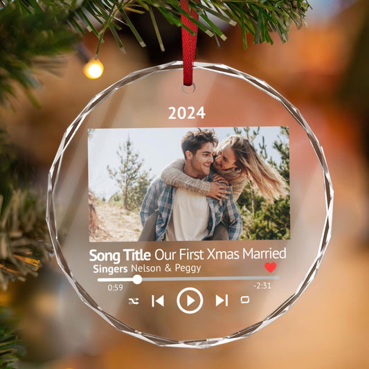 A custom crystal glass ornament from Golden Value SG displays a music player interface featuring &quot;Our First Xmas Married&quot; by Nelson &amp; Peggy, 2024. It includes a picture of a couple with the woman happily riding piggyback.