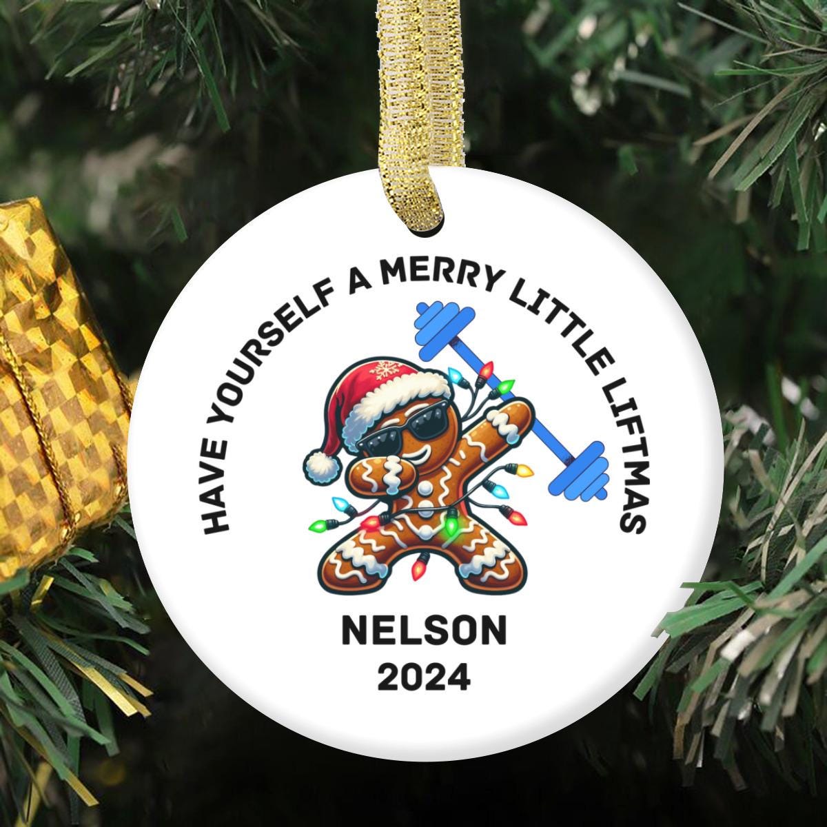 The Merry Liftmas Weightlifting Ceramic Ornament features a gingerbread man lifting weights while wearing sunglasses and a Santa hat, with the phrase "Have Yourself a Merry Little Liftmas." It's an ideal Christmas gift for gym enthusiasts or bodybuilders. Nelson 2024.