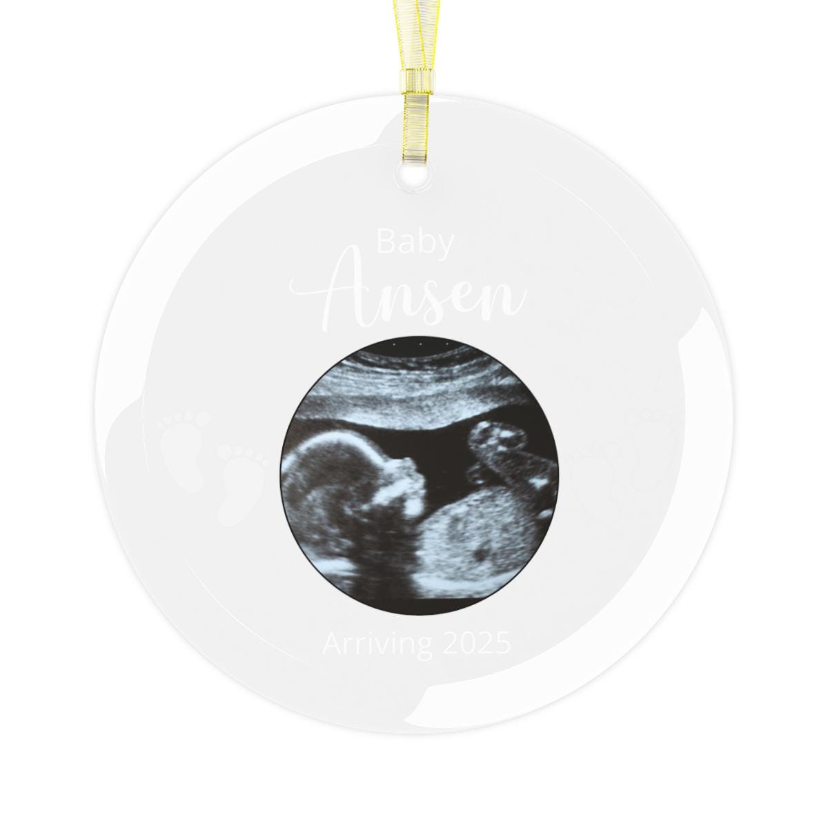 Custom Ultrasound Photo GLASS Ornament showcasing an ultrasound image with the text "Baby Ansen, Arriving 2025" and a tiny footprints design. This personalized keepsake is elegantly presented on a circular ornament with a yellow ribbon, making it ideal for a touching pregnancy announcement.