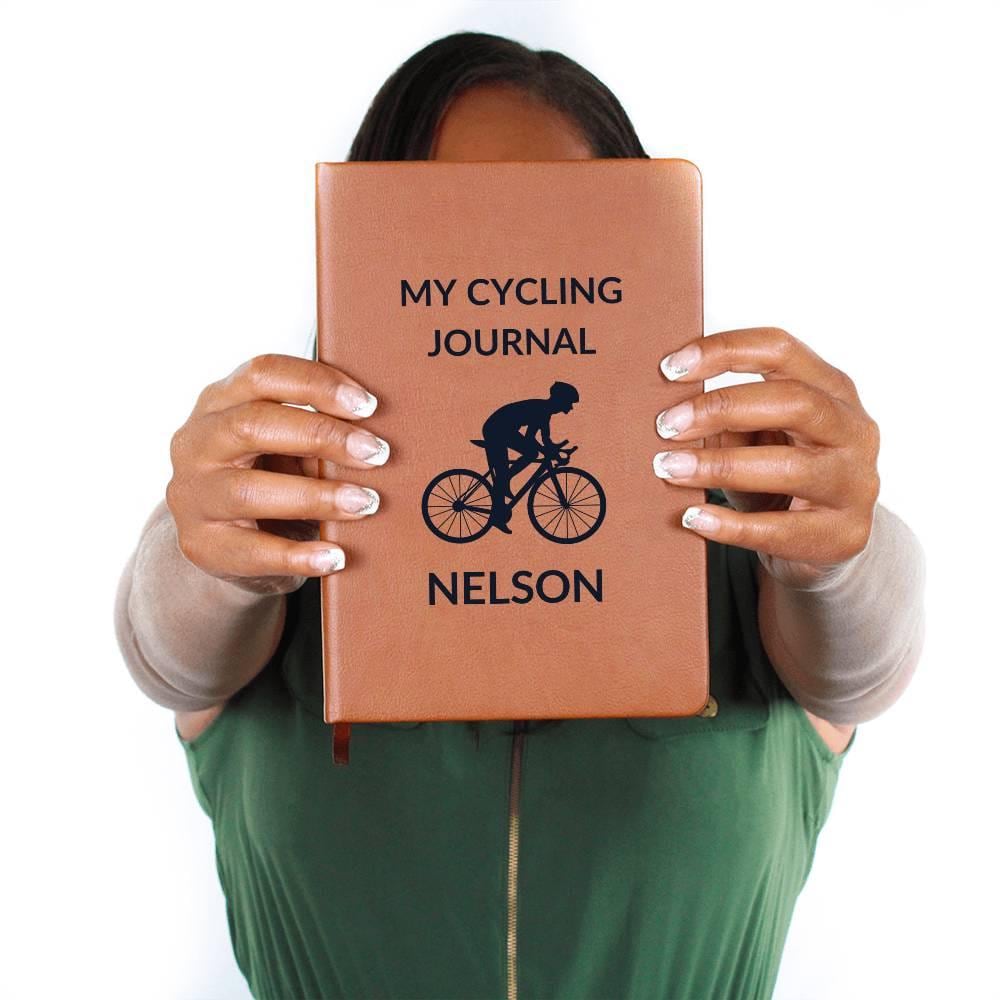 A person holds the "Personalized Leather Cycling Journal For Men," featuring a cyclist graphic and the name "Nelson.