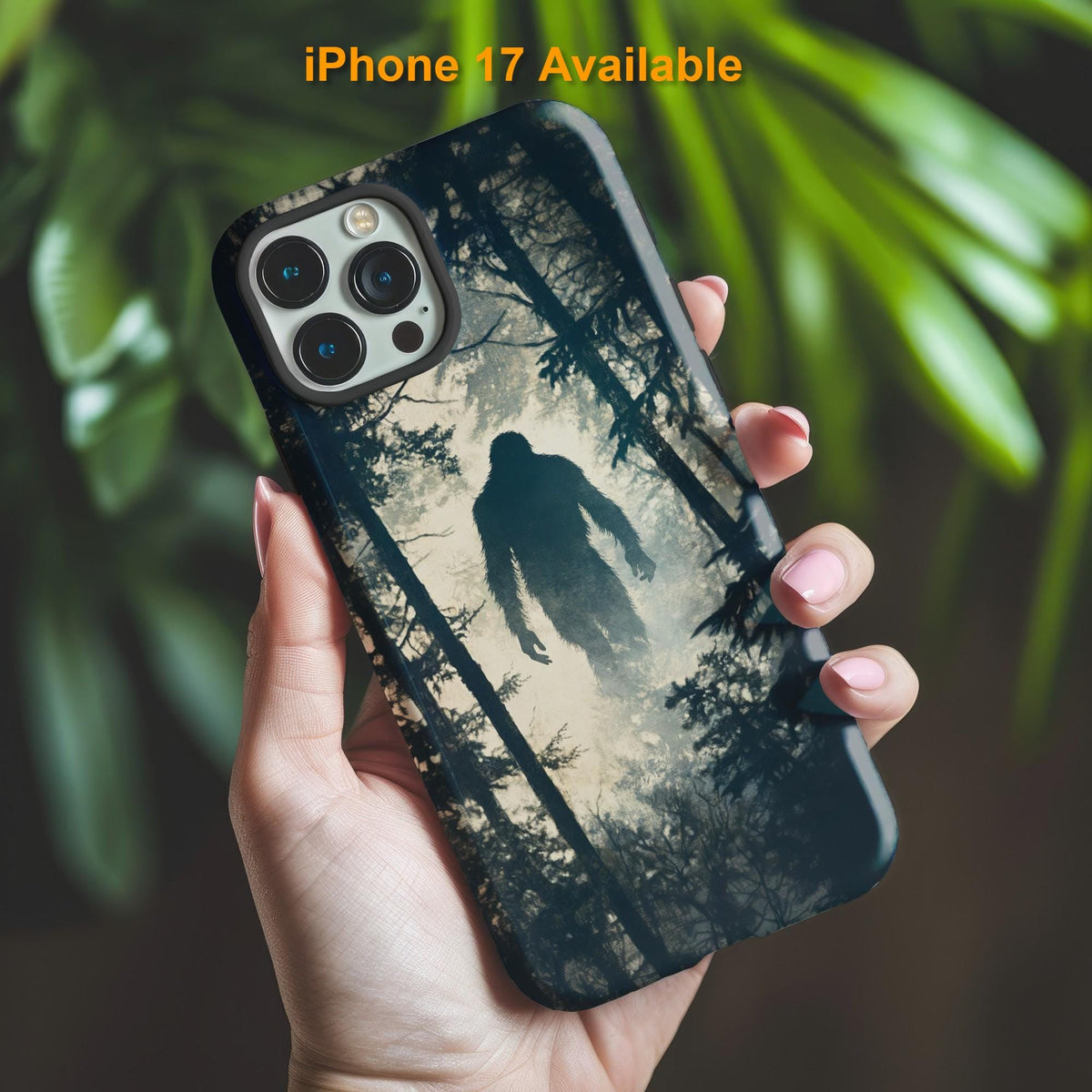 A hand holds the Golden Value SG Big Foot Silhouette Phone Case, showing a large creature's silhouette striding through a dense, foggy forest with blurred green leaves in the background.