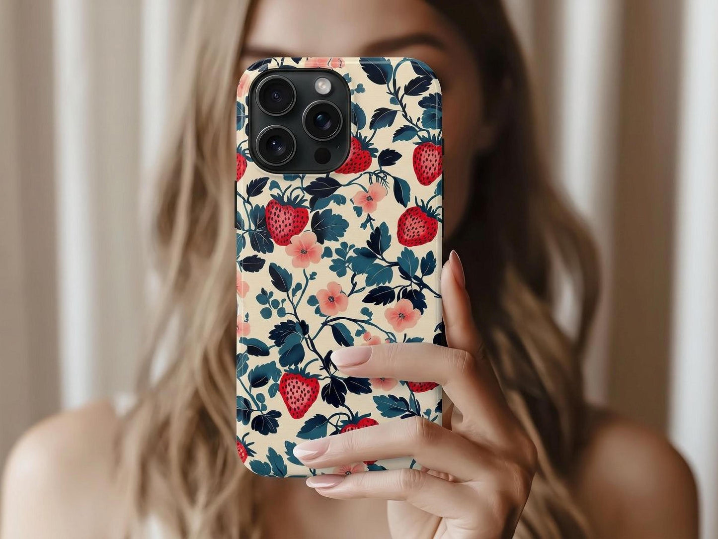 A woman with light brown hair holds up a Golden Value SG Strawberry Phone Case, featuring red strawberries, navy blue leaves, and pink flowers on beige.