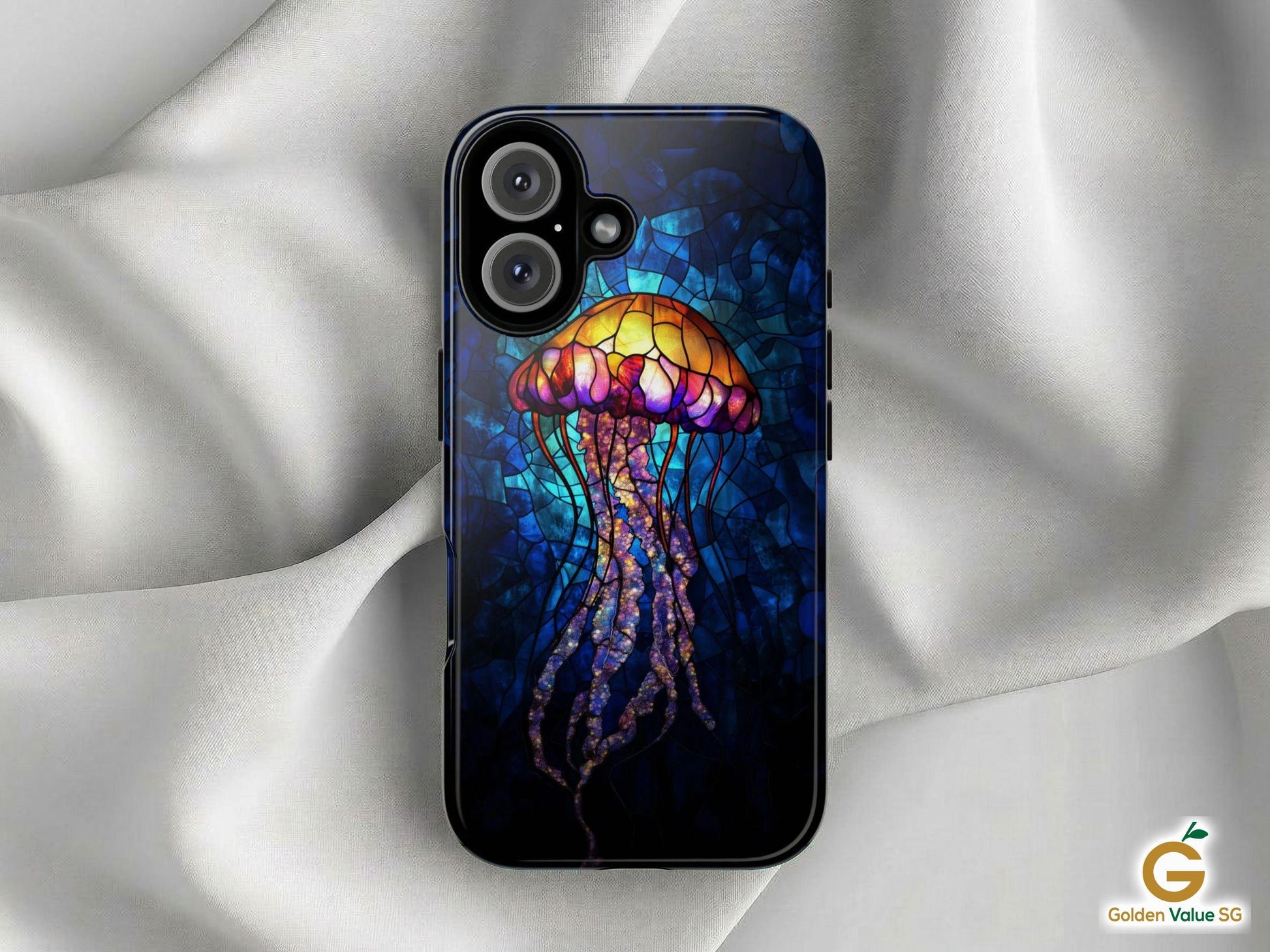 The Stained Glass Jellyfish Phone Case by Golden Value SG features a luminous jellyfish. The jellyfish glows with vibrant shades of yellow, orange, pink, and purple against a deep, dark blue oceanic background. The intricate mosaic patterns and black outlines mimic real stained glass art, creating a beautiful bioluminescent underwater aesthetic. The case is shown lying on light gray silk with the Golden Value SG logo at the bottom right.
