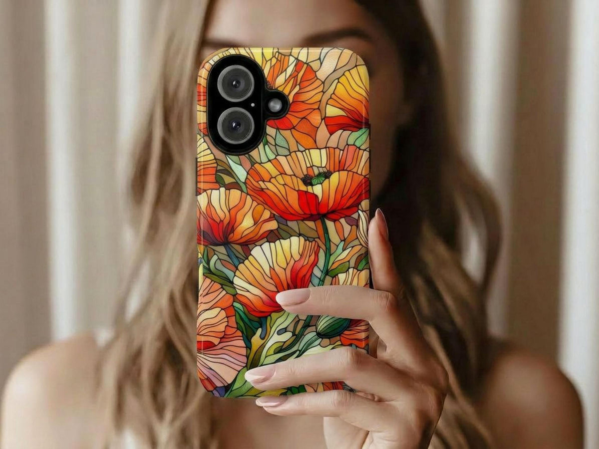 A person holds up a phone case featuring a colorful faux stained glass poppy flower pattern.