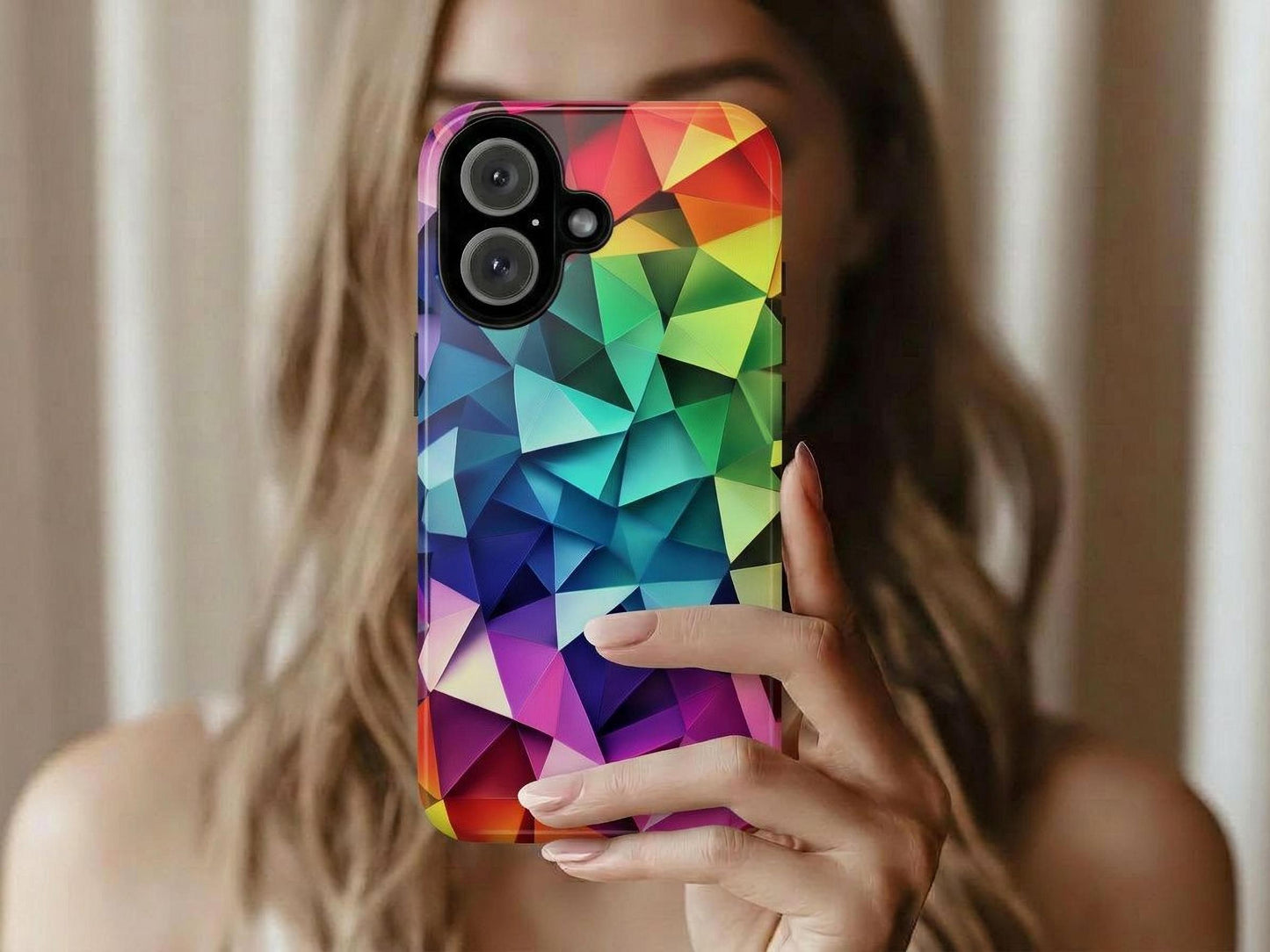 A person holds up a smartphone case featuring a vibrant multi-colored geometric mosaic design.