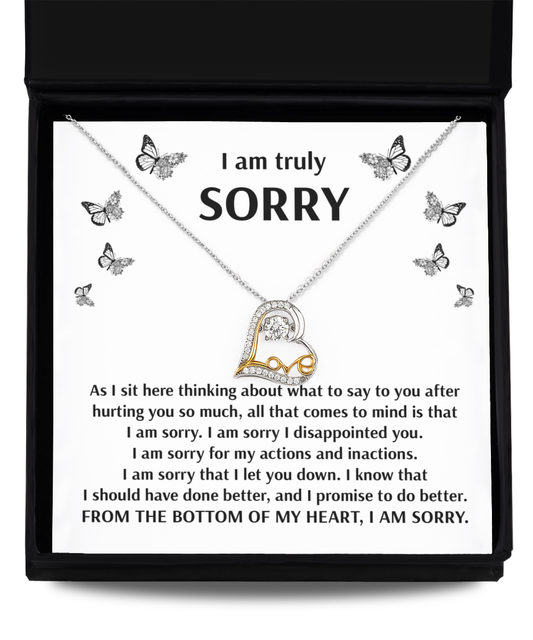 A sterling silver heart-shaped "Sorry-Done Better- Love Dancing Necklace" with a note expressing profound apologies, remorse, and a promise to do better. The background features butterflies and the word "SORRY" in bold.