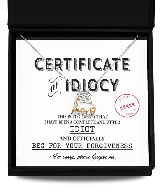 A Sorry-Certificate Of Idiocy, labeled "Certificate of Idiocy," with a .925 sterling silver Love Dancing Necklace draped over it. The certificate apologizes for idiocy and asks for forgiveness.